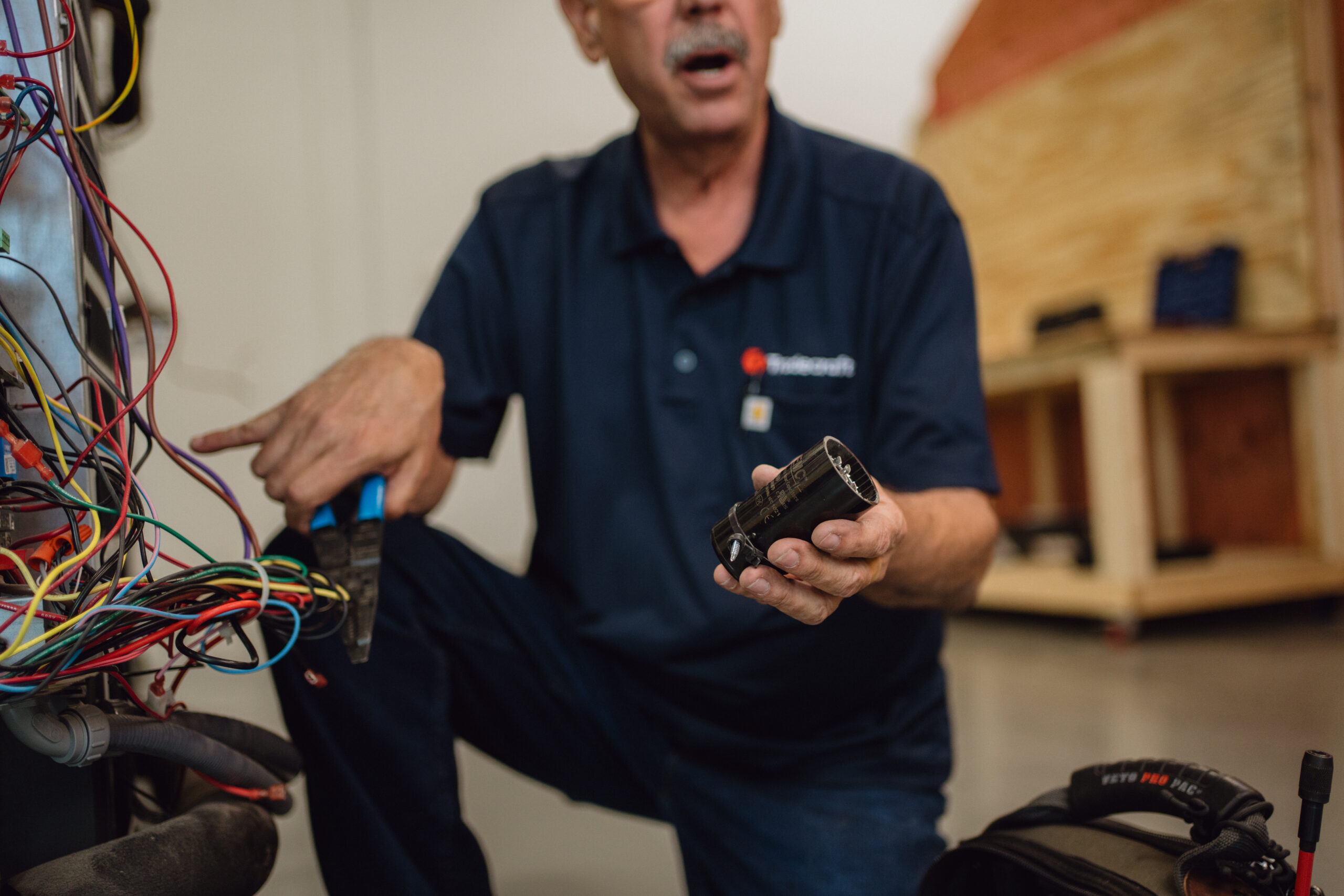 Instructor explaining HVAC capacitor and component functions
